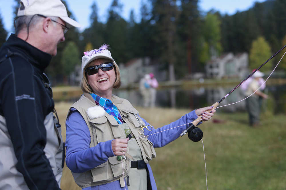 Dale Flick, of Portland, left, helps Carol O'Bryant, of Bend, Ore., practice fly casting during the Casting for Recovery retreat on Oct. 19, 2014 at Black Butte Ranch. The weekend-long retreat focused on fly fishing is for survivors of breast cancer. (AP Photo/The Bulletin, Joe Kline)