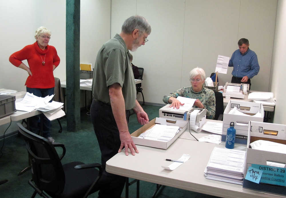 Election workers, from left, Lorraine Derr, David Clover, Deborah Craig and Mel Perkins,  help count ballots cast during the Nov. 4 general election on Tuesday, Nov. 11, 2014, in Juneau, Alaska. Officials on Tuesday began counting absentee, early-voted and questioned ballots remaining from the election. (AP Photo/Becky Bohrer)