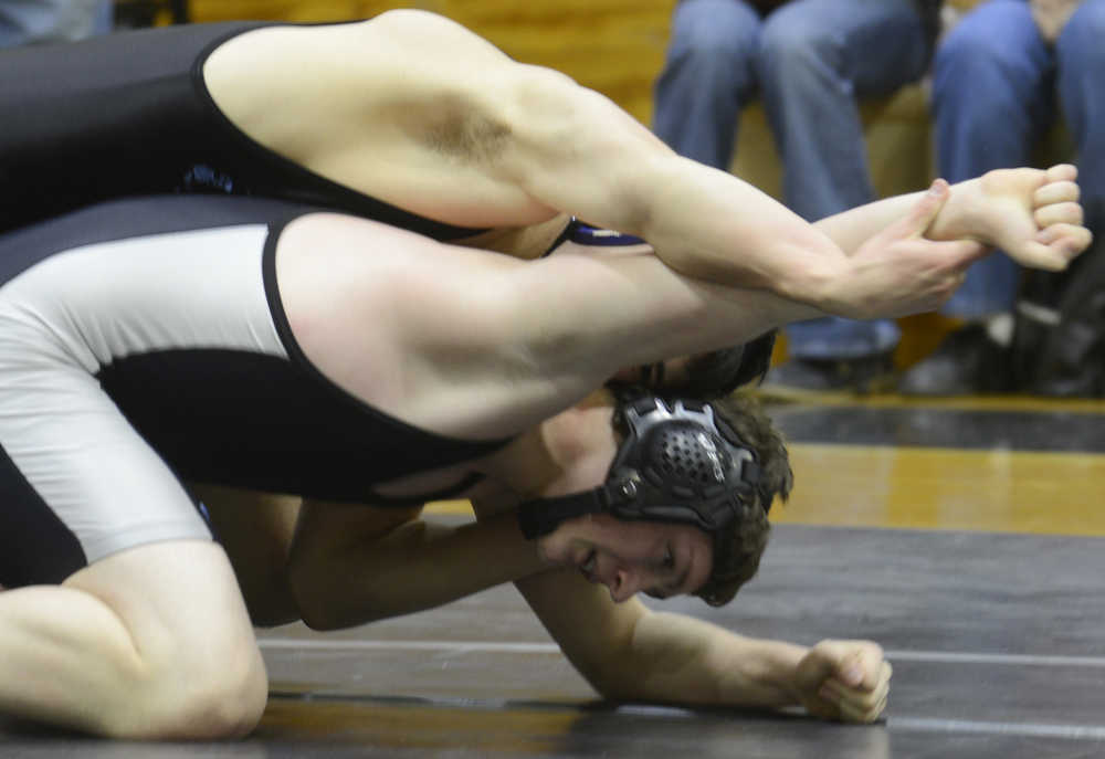 Photo by Kelly Sullivan/ Peninsula Clarion Nikiski Bulldogs' Andrew Pennison in the 152-pound weight class keeps from being pinned by Dillingham Wolverines' Darren Napoli Thursday, November 13, 2014, at Nikiski High-Middle School in Nikiski, Alaska.