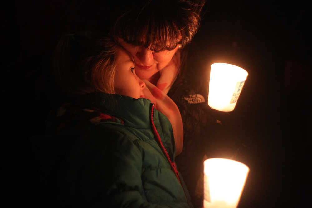 Photo by Dan Balmer/Peninsula Clarion Soldotna resident Colleen O'Connell kneels down next to her grand-daughter Colbie Broyles, 3, during a candlelight vigil Thursday at Farnsworth Park in Soldotna. The vigil, attended by nearly 100 people, was to raise awareness for homeless students.