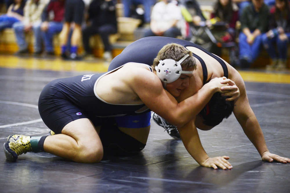 Photo by Kelly Sullivan/ Peninsula Clarion  Nikiski Bulldogs' Luke Johnson in the 220-pound weight class tries to push Soldotna Stars' Taylor Macree's head to the mat Saturday, November 15, 2014, at Nikiski High-Middle School in Nikiski, Alaska.