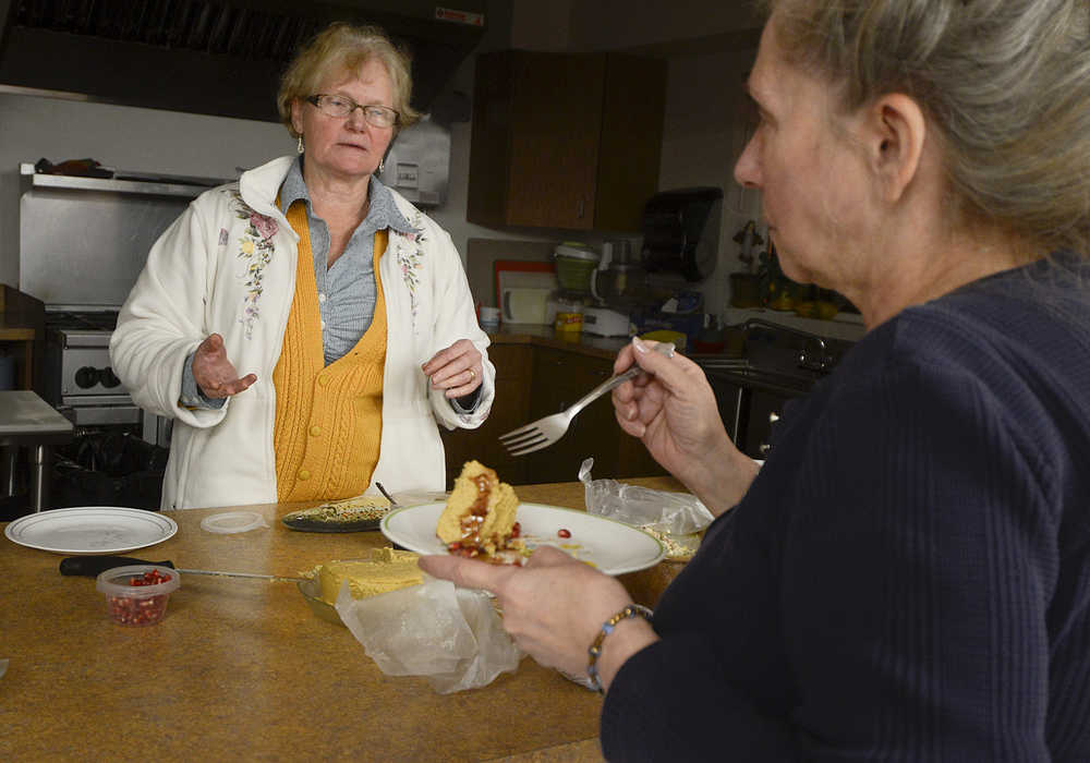 Photo by Rashah McChesney/Peninsula Clarion Colleen Sonnevil gives Lisa Kendall a piece of pumpkin pie cheesecake during a nutrition class at the Kenai Peninsula Food Bank on Tuesday Nov. 11, 2014 in Soldotna, Alaska. On Tuesday, Sonnevil's class had french onion soup and beer batter bread roll with swiss cheese melted on it and a chicken salad and pita bread. Sonnevil is also offering the class on Thursday at 5:30 p.m. The group will be making beef stroganoff.