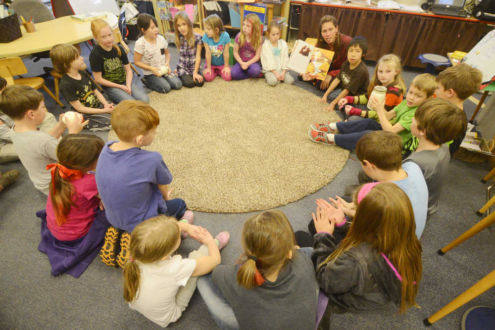 Photo by Kelly Sullivan/ Peninsula Clarion Students in primary grade teacher Jennifer Hubbard's class listen to a modern version of the folktale "Stone Soup," which the school traditionally cooks ever year before Thanksgiving Tuesday, November 25, 2014, at Soldotna Montessori in Soldotna, Alaska.