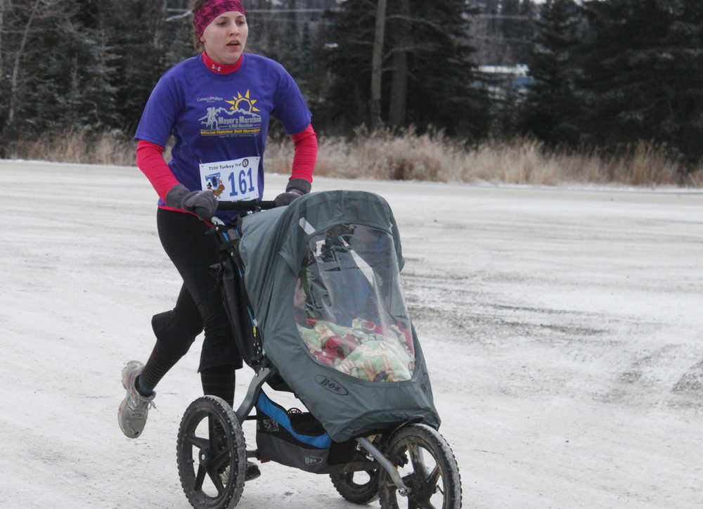 Photo by Kelly Sullivan/ Peninsula Clarion Annaleah Karren pushed her daughter Emma and son Robert on the Unity Trail during the T200 Turkey Trot 5k and 10k Run, Friday, Nov. 28, 2014, at the Soldotna Regional Sports Complex in Soldotna, Alaska. Tsalteshi Trails Association teamed up Tustumena 200 Sled Dog Race for this year's fourth annual event.