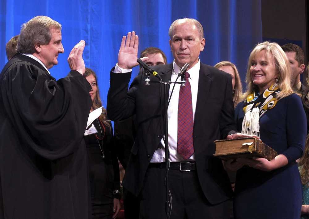Bill Walker, center, is sworn in as Alaska's new governor as Alaska Supreme Court Justice Daniel Winfree, left, administers the oath of office on Monday, Dec. 1, 2014, in Juneau, Alaska. Also pictured at right is Walker's wife, Donna. The Bible on which Walker took his oath has been in his family since the 1800s, according to his spokeswoman. (AP Photo/Becky Bohrer)