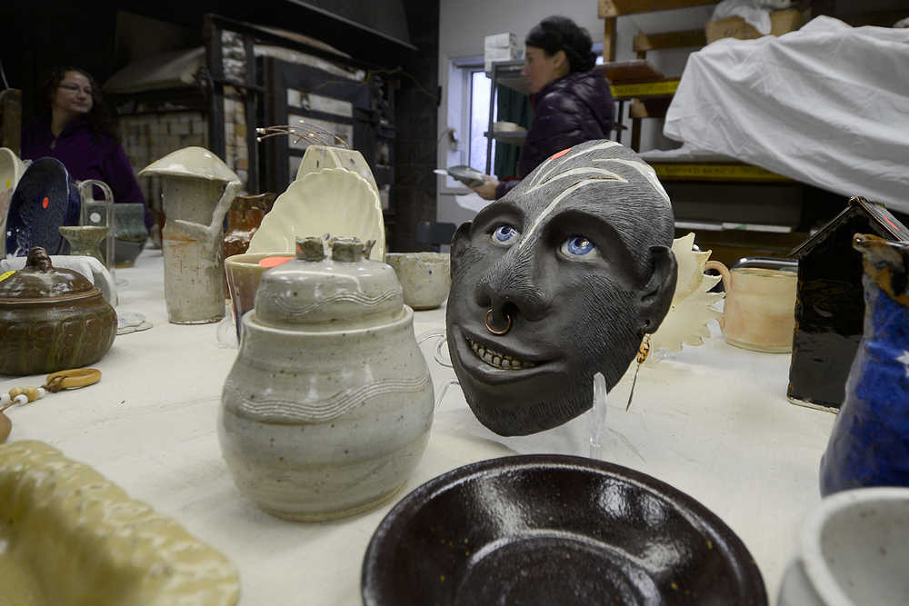 Photo by Rashah McChesney/Peninsula Clarion  Two potters discuss a glaze near a table of goods on sale during the Kenai Potters Guild sale Saturday Dec. 6, 2014 in Kenai, Alaska. The Guild will begin offering lessons in January