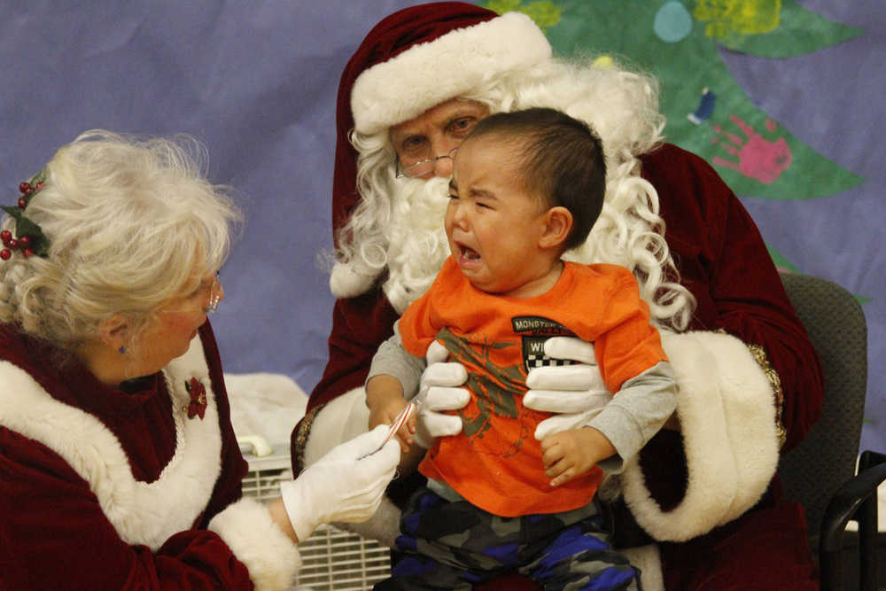 This photo taken Dec. 6, 2014, shows a crying child unsure of what to make of Santa Claus in Shishmaref, Alaska. The Alaska National Guard provided transport for the good Samaritan program Operation Santa, which took gifts and schools supplies to about 300 children in the Inupiat Eskimo community. (AP Photo/Mark Thiessen)