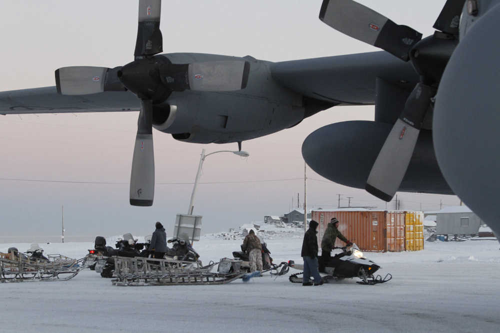 This photo taken Dec. 6, 2014, shows Christmas toys and other supplies being loaded from a C130 military transport plane onto sleds being pulled by snowmobiles in Shishmaref, Alaska. The Alaska National Guard provided transport for the good Samaritan program Operation Santa, which took gifts and schools supplies to about 300 children in the Inupiat Eskimo community. (AP Photo/Mark Thiessen)