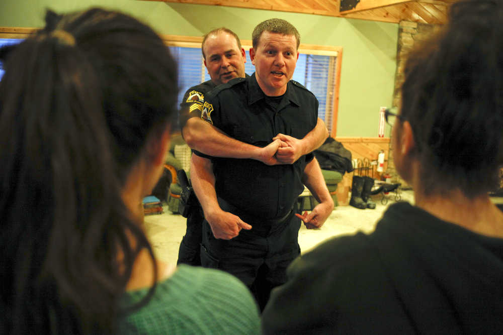 Photo by Rashah McChesney/Peninsula Clarion  Kenai police officers Jay Sjogren and Alex Prins demonstrate manuevers to escape an attacker during a Teens on Target self defense class on Thursday Dec. 11, 2014 in Kenai, Alaska.