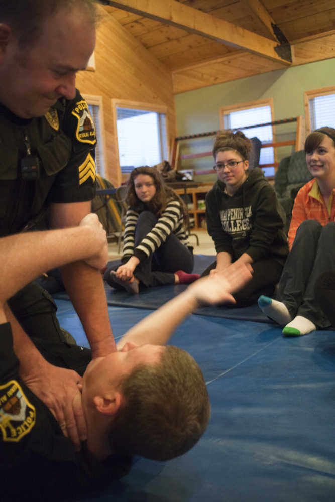 Photo by Rashah McChesney/Peninsula Clarion  Kenai police officers Jay Sjogren and Alex Prins demonstrate a manuever during a Teens on Target self defense class on Thursday Dec. 11, 2014 in Kenai, Alaska.