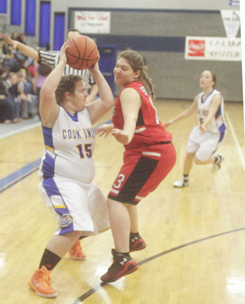 Photo by Kelly Sullivan/ Peninsula Clarion Cook Inlet Academy Eagle's Kendall Taplin tries to pass the ball around Seldovia Lady Sea Otters' Violet Mitchell Saturday, Dec. 20, 2014, at Cook Inlet Academy in Soldotna, Alaska.