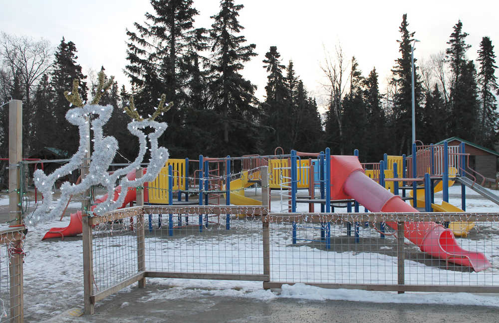 Christmas lights adorn a new gate to the playground at the Kenai Municipal Park on Forest Drive in Kenai. (Photo by Will Morrow/Peninsula Clarion)