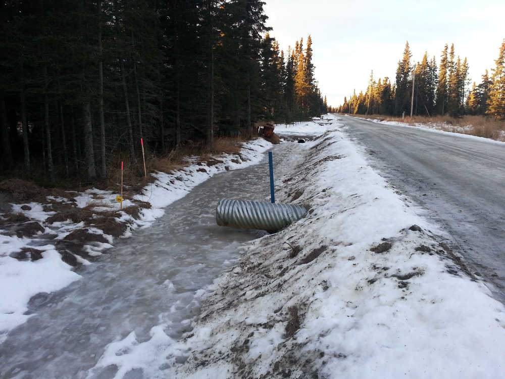 Photo by Dan Balmer/Peninsula Clarion A culvert underneath Buoy Avenue drains frozen retention water in a ditch dug out to keep surface water off the street. Photo taken December 19, 2014. Kenai Peninsula road service crews made ditch improvements to Buoy Avenue, which was built in 2003, this fall after the road saw significant flooding in 2013 because it was not built to borough road standards.