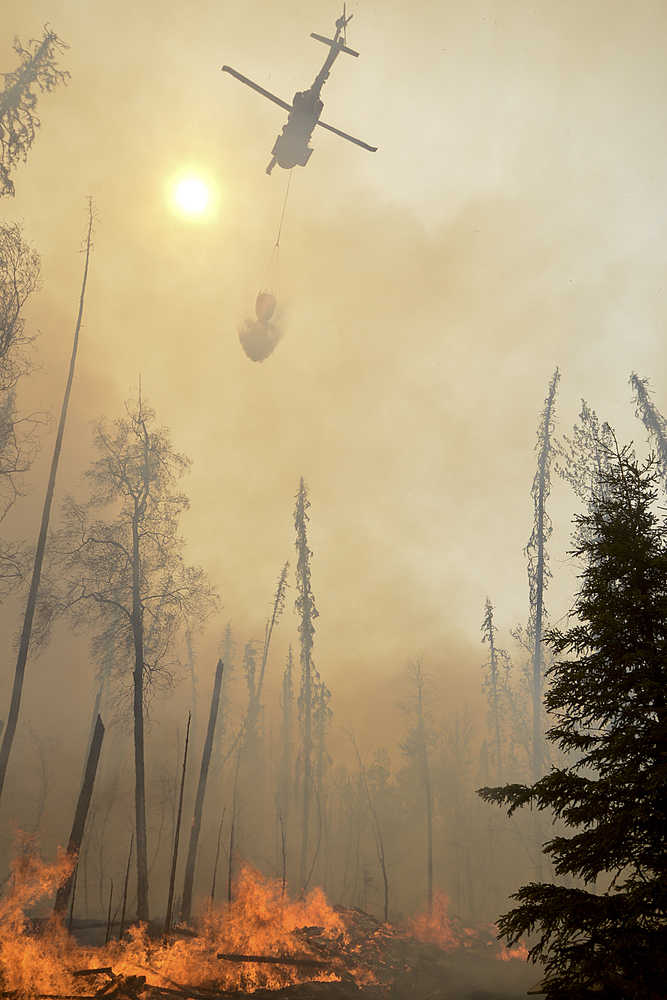 Photo by Rashah McChesney/Peninsula Clarion A Black Hawk helicopter dumps water on a portion of the Funny River Wildfire Monday May 26, 2014 in the Funny River community in Soldotna, Alaska. The wildfire has burned more than 156,000 acres and prompted three evacuations on the Kenai Peninsula.