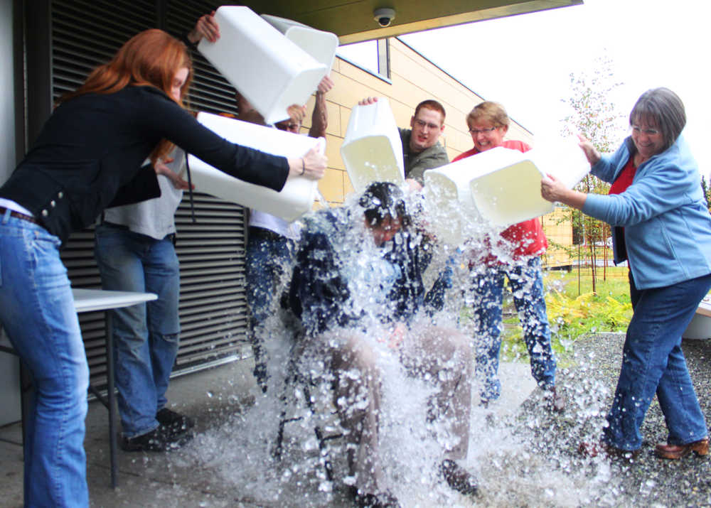 Photo by Kelly Sullivan/ Peninsula Clairon Residence Advisors Robert Goerdt and Sean McBride, desk attendant Zach Moore and Residence Life Coordinator Leslie Byrd dump buckets of ice water on  Kenai Peninsula College Associate Director of Residence Life Tammie Willis Friday, Sept. 05, 2014, at the Kenai Peninsula College Residence Hall in Soldotna, Alaska. Willis was asked by Byrd to take part in the ALS Ice Bucket Challenge.