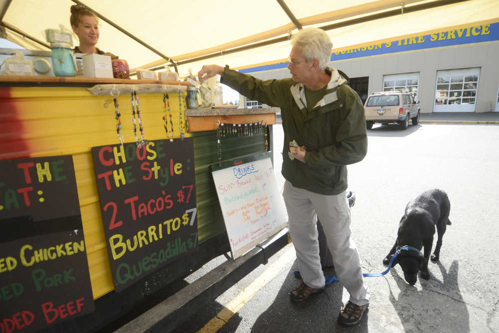 Photo by Kelly Sullivan/ Peninsula Clarion Dean Bostwick and his dog Buddy stop at the AK Taco Shack food truck, for the first time while waiting to get his tires fixed at Johnson's Tire Service, Friday, August 29, 2014 in Soldotna, Alaska.