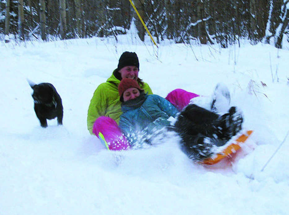 ADVANCE FOR USE SUNDAY, JAN. 11 - In this photo taken on Dec. 28, 2014, Cassidy Saunders, front, and Corey DiRutigliano get to the bottom of the hill covered in snow during a sledding trip to Ester Hill in Fairbanks, Alaska.  Picking the right hill and to a lesser extent the right sled, makes the difference in sledding. (AP Photo/ Fairbanks Daily News-Miner, Sam Friedman)
