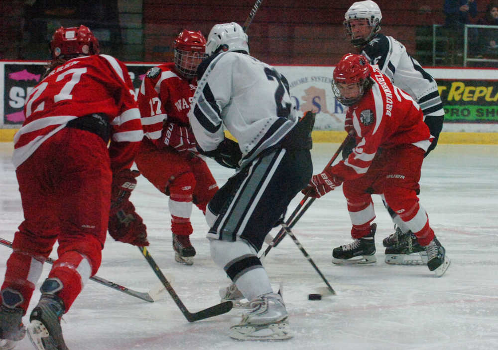 Photo by Kelly Sullivan/ Peninsula Clarion Soldotna High School Stars' Trevor Witthus maintains control of the puck from a group of Wasilla Colony High School Knights, Thursday, January 15, 2015, at the Soldotna Regional Sports Complex in Soldotna, Alaska.