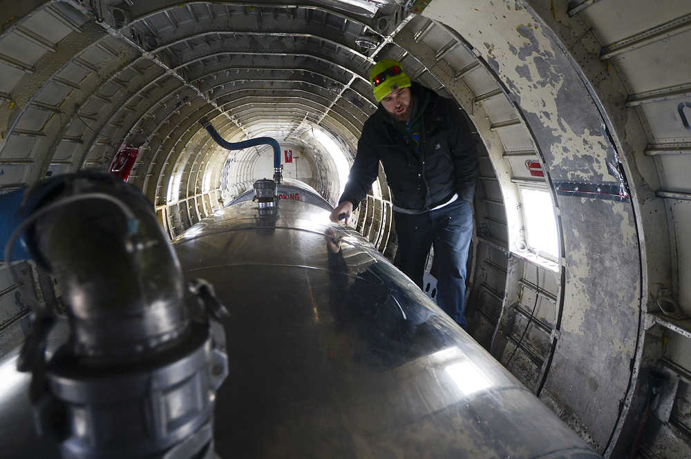 Photo by Rashah McChesney/Peninsula Clarion First Officer Zachary Sawyer walks through the belly of a WWII-era plane used by Everts Air Fuel Service after the plane landed at the Kenai airport to refill its tanks on Tuesday Jan. 13, 2014 in Kenai, Alaska.