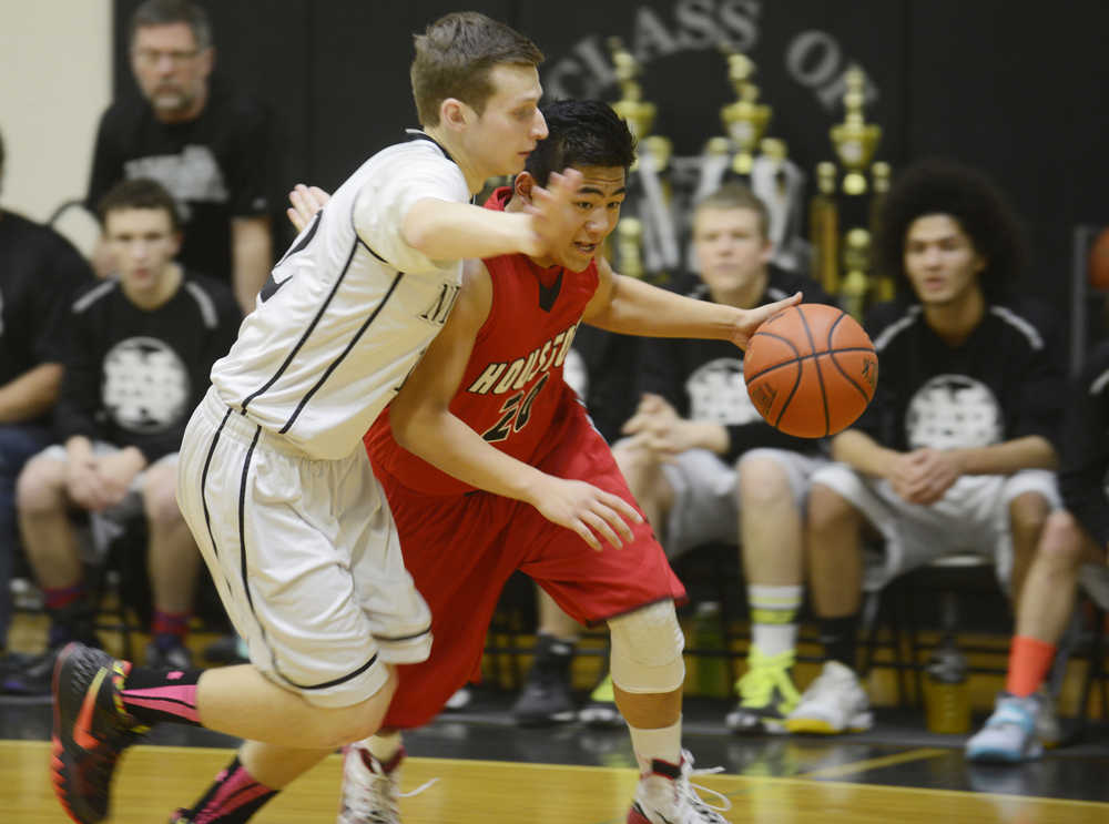 Photo by Kelly Sullivan/ Peninsula Clarion Nikiski Bulldog Cade Anderson tries to block a pass by Houton High School Hawks Lai Saechao, Saturday, Jan. 17, 2015, at Nikiski Middle-High School in Nikiski, Alaska.