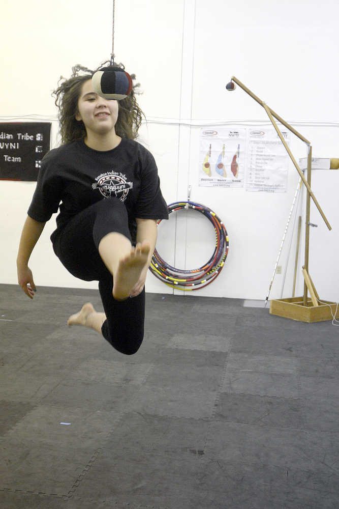 Photo by Rashah McChesney/Peninsula Clarion  Kya Ahlers, 13, grins after realizing that she had hit a bag that was lifted 70-inches off the ground as she practiced for the Native Youth Olympics on Wednesday Jan. 14, 2015 at the Yaghanen Youth Center in Soldotna, Alaska. Ahlers had been practicing for several minutes when Kenaitze Indian Tribe Yaghanen programs director Michael Bernard lifted the bag as she looked away. She said it was the highest she'd ever managed to kick the bag.