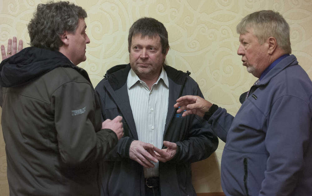 Photo by Rashah McChesney/Peninsula Clarion In this March 21, 2013 file photo, Ricky Gease, executive director of the Kenai River Sportfishing Association, former Board of Fisheries member Vince Webster and Karl Johnstone, Board of Fisheries chairman, talk during a break at a Board of Fish meeting in Anchorage, Alaska. Johnstone announced his resignation on Tuesday.  Governor Bill Walker appointed Cook Inlet fisherman Roland Maw to replace him.