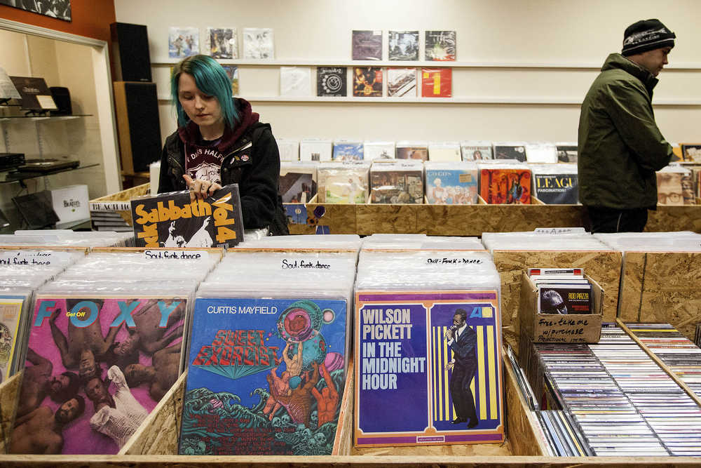 ADVANCE FOR SATURDAY, JAN. 24 AND THEREAFTER  In this Jan. 15, 2015 photo, Ellie Walz, 24, digs for vinyl at the new Anchorage record store Obsession Records in Anchorage, Alaska. Obsession Records opened their doors at the beginning of December, relying completely on word of mouth and social media. (AP Photo/Alaska Dispatch News, Tara Young)