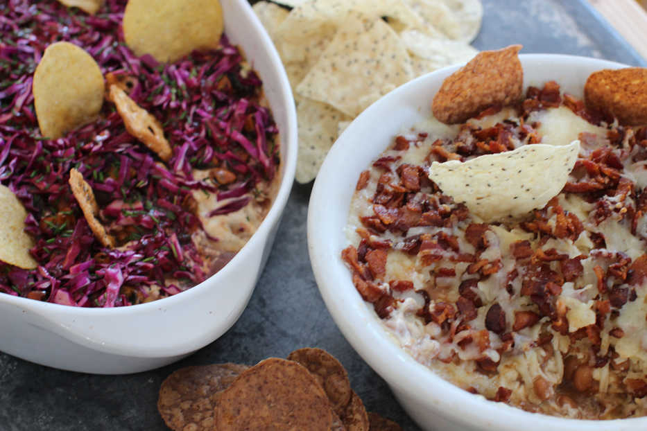 This Jan. 26, 2015 photo shows the Seattle super seven dip, left, and New England super seven dip in Concord, N.H. The Seattle dip is made with teriyaki-seasoned Dungeness crabmeat, creamy cheese, caramelized onions, smoked mussels, purple cabbage slaw and blackberry vinaigrette. The New England dip is made with barbecued pulled pork topped with skillet sauteed apples and butter. (AP Photo/Matthew Mead