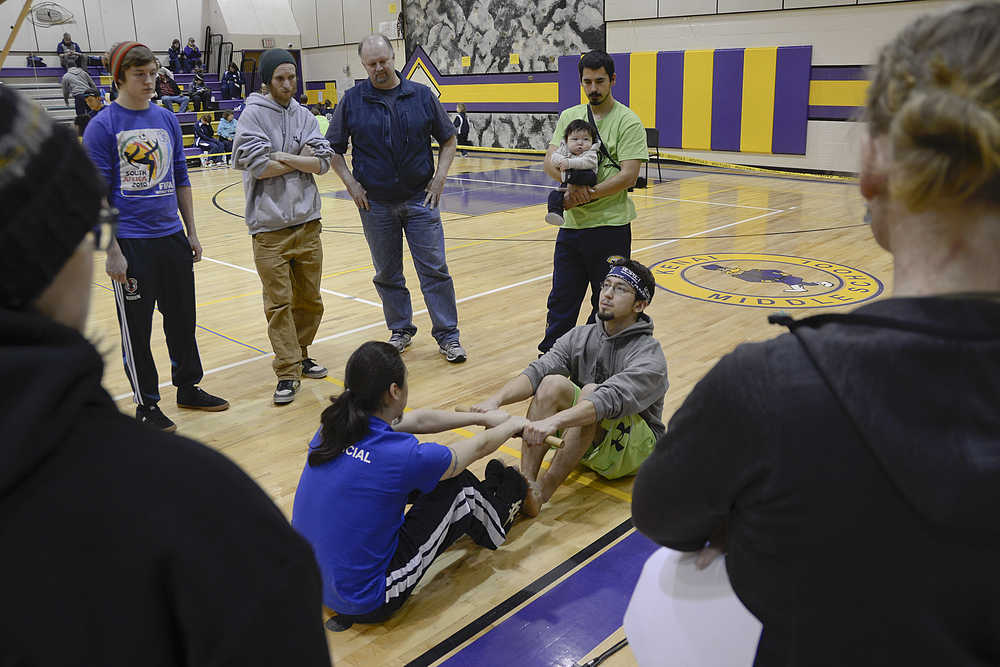 Photo by Rashah McChesney/Peninsula Clarion  Two volunteers demonstrate proper technique for an Eskimo Stick Pull during the Native Youth Olympics on Saturday Jan. 24, 2015at Kenai Middle School in Kenai, Alaska. The regional event drew teams from Anchorage, Seward, Kenai, Chickaloon and Tebughna. Teams competed for medals over the weekend of events showcasing the athleticism of Alaska's indigenous cultures.