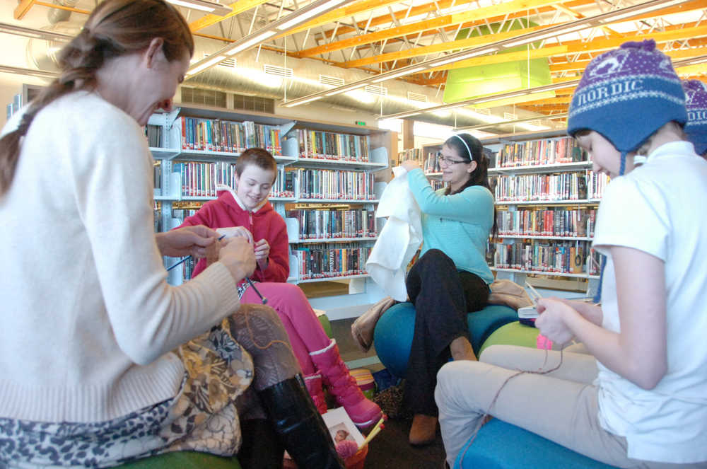 Photo by Kelly Sullivan/ Peninsula Clarion Amy Lou Pascucci leads the Knit 2 Read 2 group for teens, Monday, Feb. 2, 2015, at the Kenai Community Library in Kenai, Alaska. The group has been meeting since October. Melita Efta, Juliana Hamilton and Amelia Johnson use different styles.