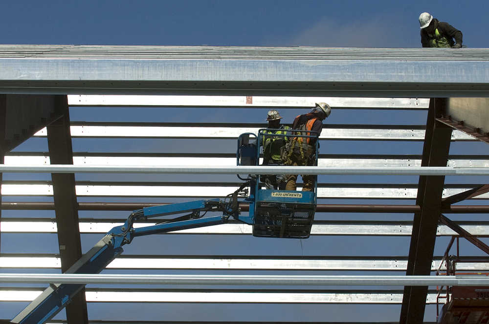 File photo/Peninsula Clarion  In this Dec. 11, 2012 file photo Charlie Martinez, Chris Luttrell and Noe Marquez, all of Hilburn Builders Inc., work on the building that holds CINGSA's compressors. Two compressors move gas from an existing pipeline into a short spur under Bridge Access Road, where it will be injected during summer months nearly a mile underground into a depleted gas reservoir for wintertime use. ENSTAR Natural Gas company has begun work on a gas transport pipeline that runs along Bridge Access Road which will connect the company's Cook Inlet facilities to the CINGSA storage facility.