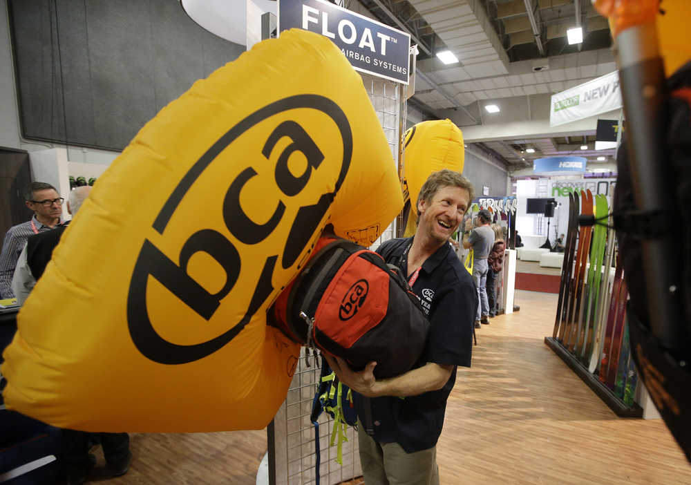 Bruce Edgerly, vice president of marketing and sales with BCA, a Boulder, Colorado-based company, holds their float avalanche airbag at their exhibit at the Outdoor Retailer Show Wednesday, Jan. 21, 2015, in Salt lake City. "It makes you a bigger object. In an avalanche, the biggest objects, like the biggest pieces of debris, end up on the surface." Air bags become more affordable and easy to use in recent years, Edgerly said. (AP Photo/Rick Bowmer)
