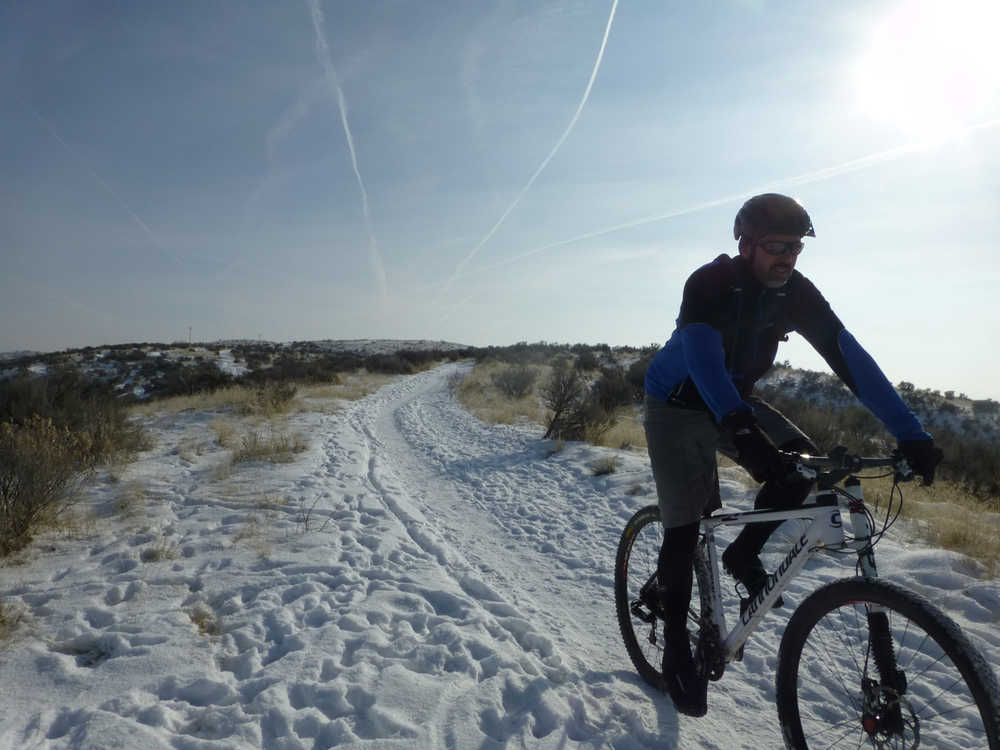 Roger Phillips rides down a snowy trail near Eagle, Idaho, Jan. 2, 2014, in this self portrait.   Regular mountain bikes can be ridden on trails with hard-packed snow. Dropping tire pressure by about 5 pounds improves traction. (AP Photo/Idaho Statesman, Roger Phillips)