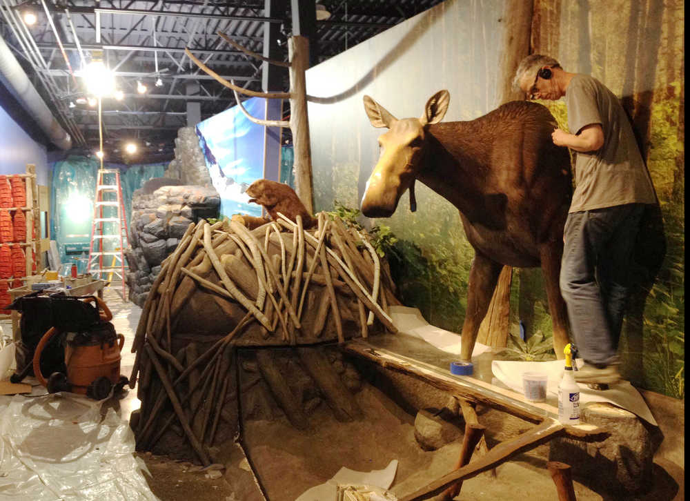 In this photo provided by the Kenai National Wildlife Refuge, workers install exhibits in the new refuge visitor center.