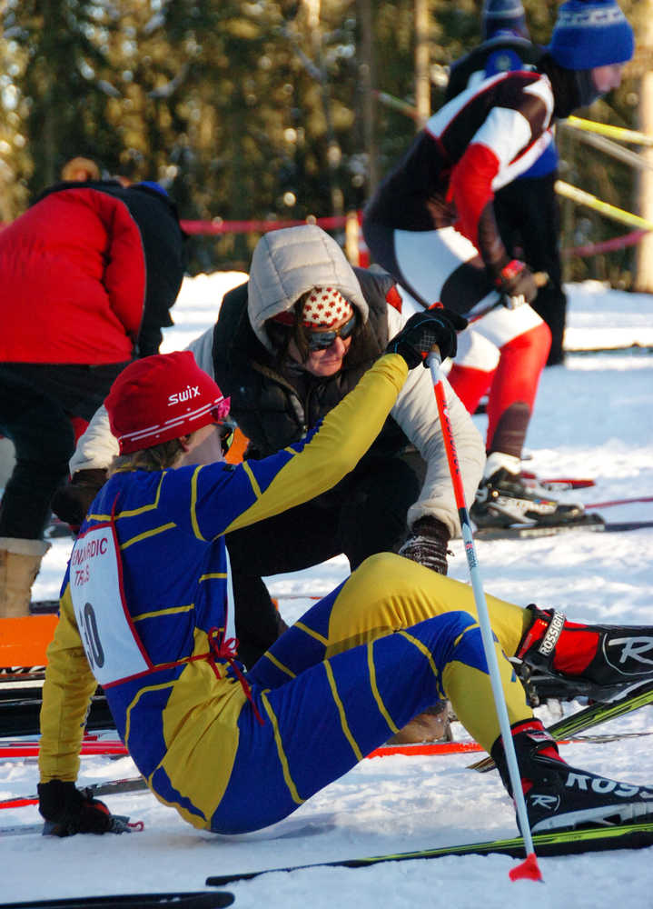 Photo by Joey Klecka/Peninsula Clarion Homer freshman Jacob Davis slips while attempting to change his skis at Friday's Kenai Peninsula Borough ski championships, held at the Tsalteshi Trails in Soldotna.