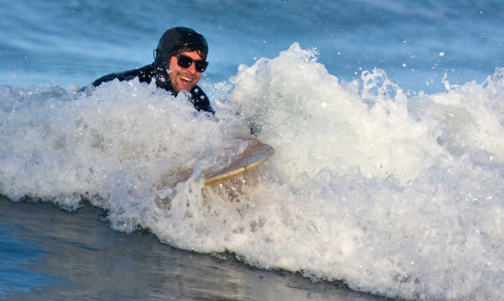 Callahan Dillon rides a final wave into Lena Beach after surfing in Juneau, Alaska, on Thursday, Feb. 5, 2015. (AP Photo/The Juneau Empire, Michael Penn)