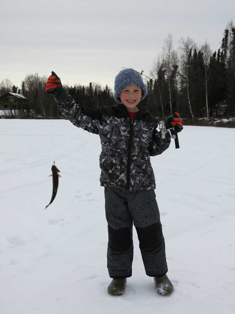 Noah Payne shows off his catch during Ice Fishapalooza Sunday on Sport Lake in Soldotna. (Photo by Dave Atcheson)