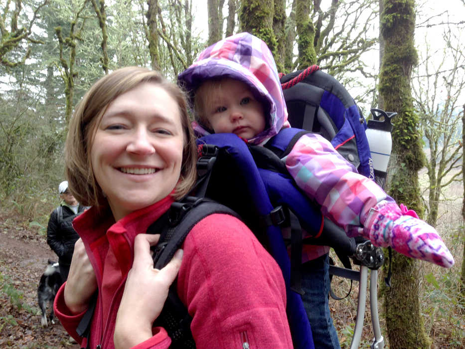 This Dec. 2014 photo provided by Amy Rockwell, Kristi Neznanski carries her daughter Hazel in a pack during a Salem Hike It Baby outing at the Croisan Trail system in South Salem, Ore.  The group called Hike It Baby, which recently opened a branch in Salem, is encouraging new parents to get outdoors by offering a supportive atmosphere on organized weekly hikes.  A collection of 118 people are part of the Salem group, and during the last two weekends, they've had hikes at the Croisan Trail system in South Salem and Kezier Rapids Park.   (AP Photo/Statesman-Journal, Courtesy of Amy Rockwell)
