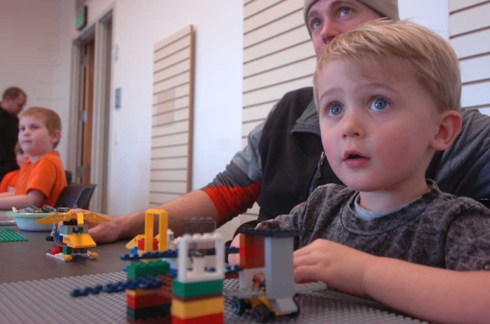 Ben Boettger/Peninsula Clarion Ivor Ledahl, with his father Brian, plays with Legos at the Kenai Public Library's monthly Lego Club event on Thursday, Feb. 19. This month's theme was spaceships.
