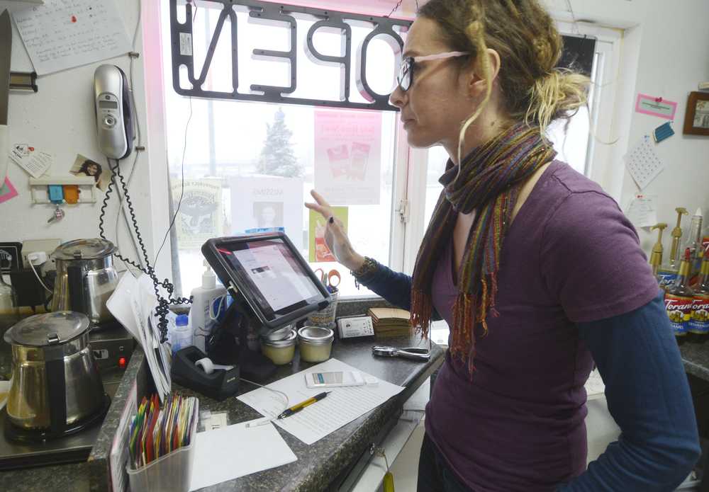 C Cups Specialty Coffees owner Amy Jackman uses the Square application on the coffee-carts iPad, which functions as the companies' Point of Sales system Monday, Dec. 1, 2014, in Kenai, Alaska. Jackman said using mobile devices for financial transactions has streamlined operations.
