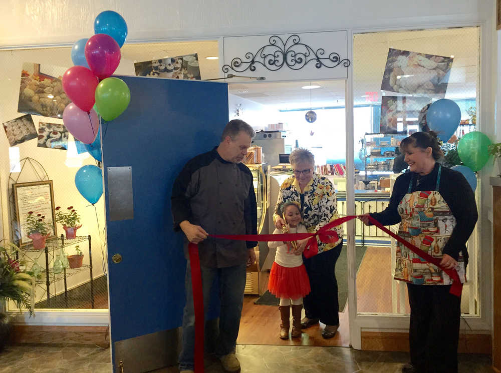 By IAN FOLEY Mayor Pat Porter and a young girl cut a ribbon held by Steve and Bobbi England on Monday, March 2 at Gotta Have Desserts in Kenai.