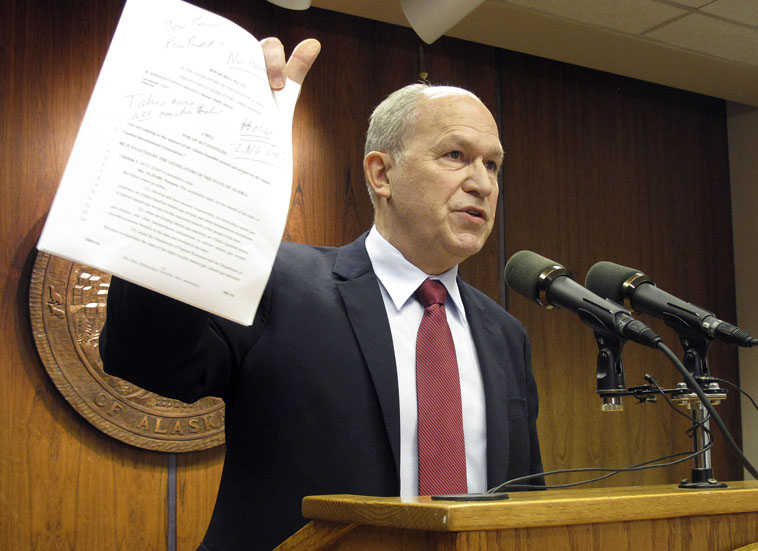 Alaska Gov. Bill Walker holds a print out of a bill introduced in the Alaska House that would limit participation by the Alaska Gasline Development Corp. in an alternate gas line project during a news conference Monday, March 2, 2015, in Juneau, Alaska. Walker expressed shock with the bill and said he would veto it if the bill reached his desk. (AP Photo/Becky Bohrer)