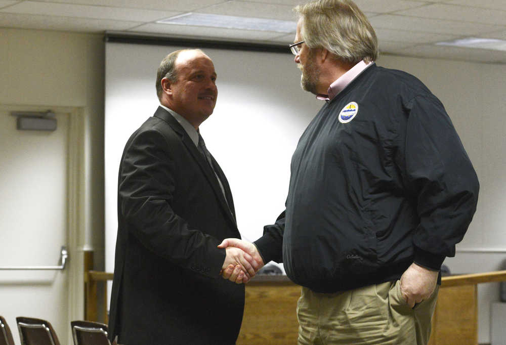 Photo by Kelly Sullivan/ Peninsula Clarion Assistent Superintendent of Instruction Dave Jones congradulates Interim Superintendent Sean Dusek after Dusek is named the new superintendent of schools Tuesday, March 3, 2015 at the Kenai Peninsula Borough Building in Soldotna, Alaska.