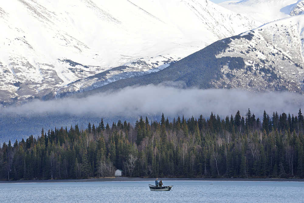 Photo by Rashah McChesney/Peninsula Clarion  Two men fish on the Kenai River Sunday March 1, 2015 in Cooper Landing, Alaska.