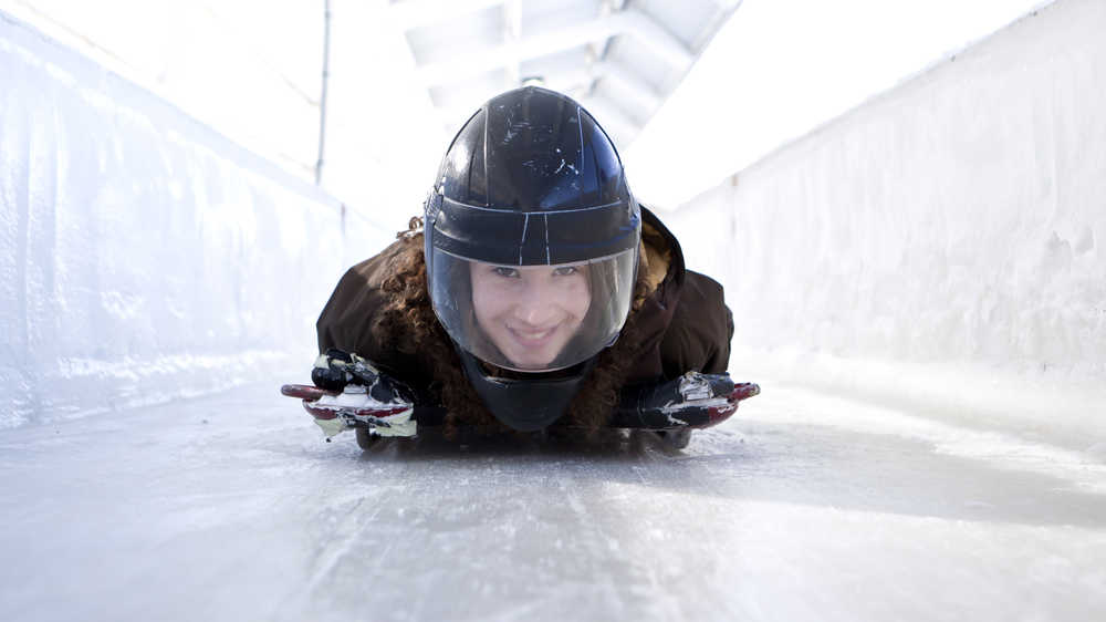 This undated photo provided by the Olympic Regional Development Authority shows  a person taking a skeleton ride at Mt. Van Hoevenberg in Lake Placid, N.Y.  For $75, visitors on winter Saturdays can take a sled ride belly down, head first on a sled the size of a throw rug. While racers take running jumps onto their sleds and can exceed 80 mph, visitors are pushed off about halfway down the run and can hit 30 to 40 mph.  (AP Photo/Olympic Regional Development Authority)