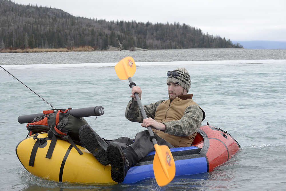 Photo by Rashah McChesney/Peninsula Clarion Thor Lindstam, of Anchorage, manuevers his inflatable raft up to the shore while fishing near Skilak Lake on Sunday March 1, 2015 near Sterling, Alaska. Lindstam said he didn't have much luck trout fishing but had caught, and released, a silver salmon.