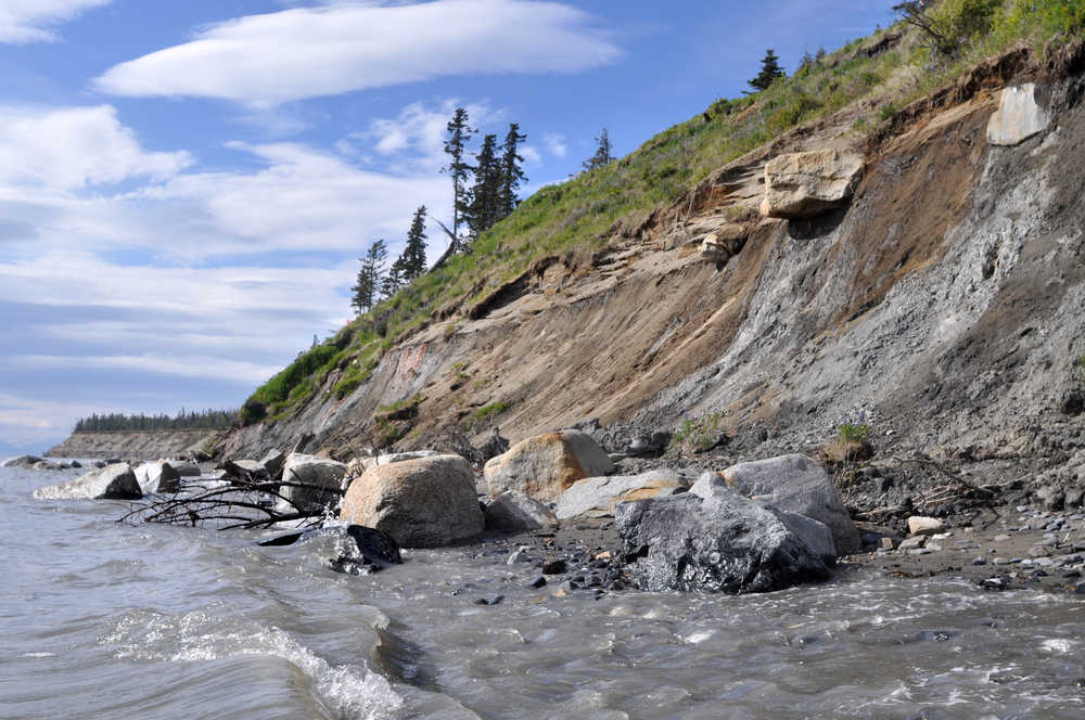 The tide and wind waves eat at the bottom of Kenai Bluff during high tide Sunday evening below Toyon Way in Kenai.