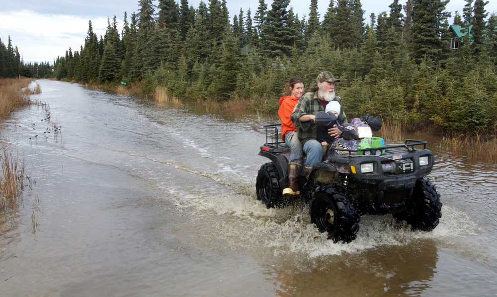 Clarion file photo In this Oct. 29, 2013 file photo, Paul Vass and Julie Wendt drive down Bore Tide Drive during a tour of the Kalifornsky area subdivision in which they live. The couple suffered and estimated $30,000 in damage to their livestock and home during the month's long groundwater-flooding event.