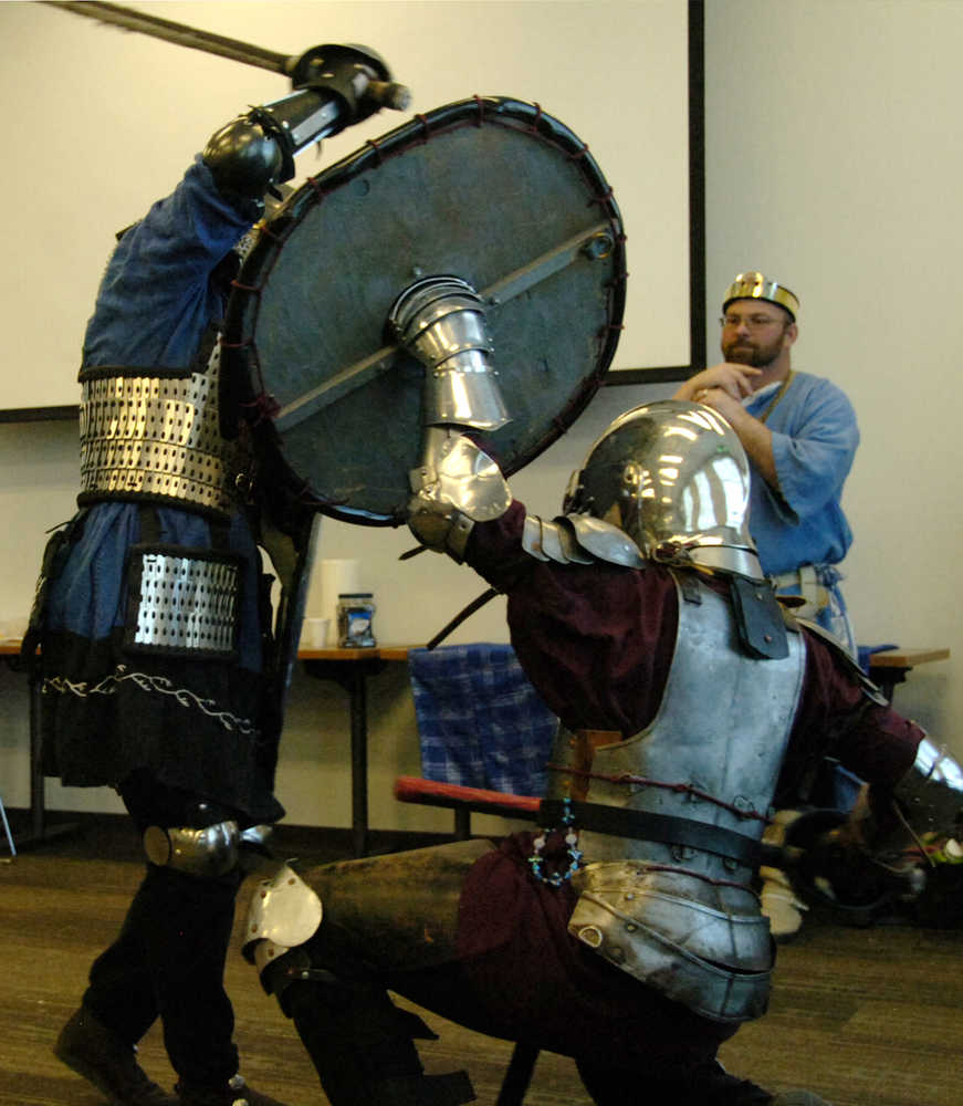 Ben Boettger/Peninsula Clarion Cindy Edmunds (left), known as Dagmar the Red, attacks Jason Notter, known as Hrothi, while Prince Shawn Denny looks on during during the Society for Creative Anachronisms Newcomers Feast at the Soldotna Public Library on Saturday, March 14.