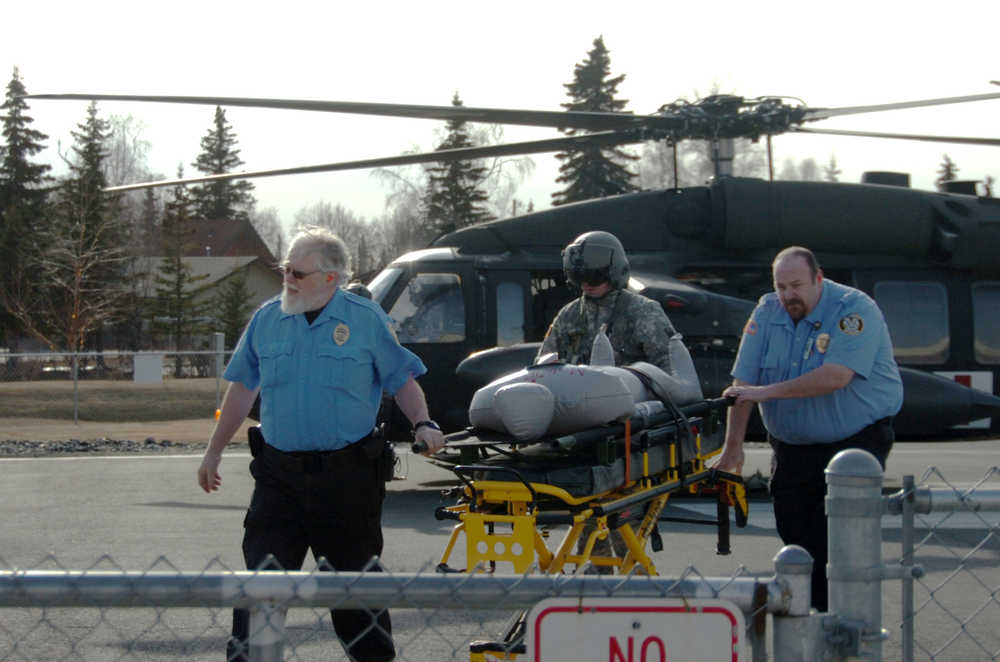 Ben Boettger/Peninsula Clarion Central Peninsula security officer Tom Randolph (left), a helicopter crew member, and security officer Richard Dominick transport an inflatable "patient" during a disaster preparedness exercise at Central Peninsula Hospital on Friday, March 20.